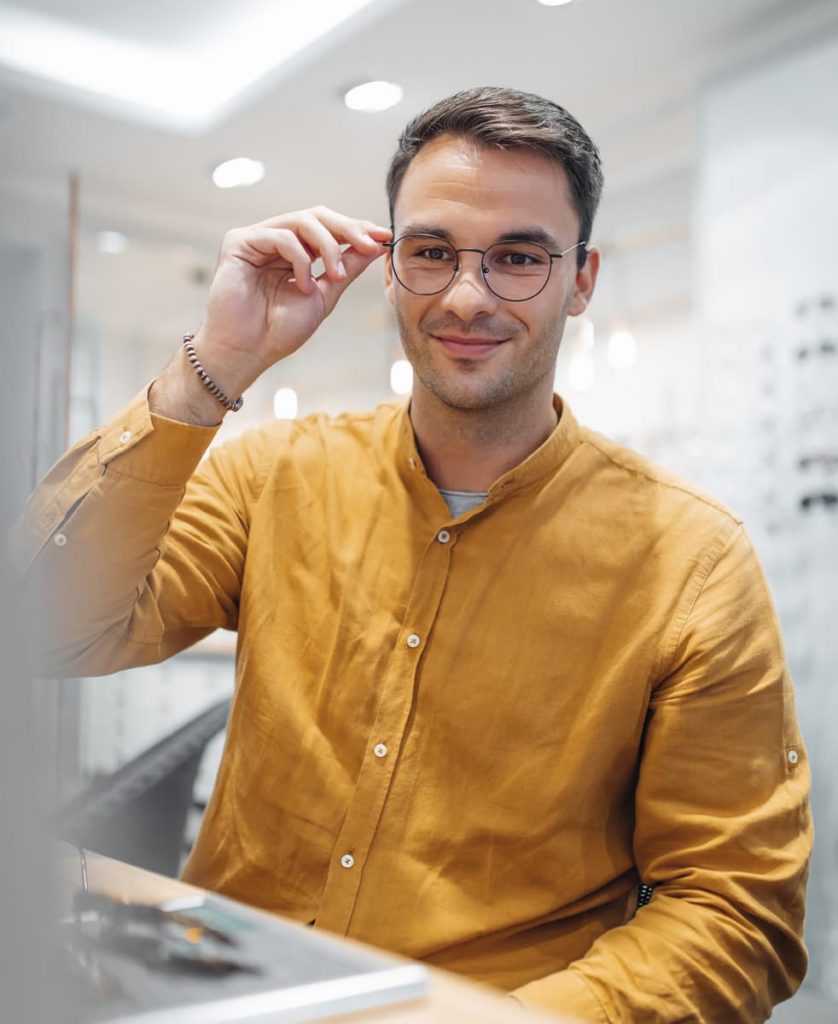 Mann mit Brille schaut in den Spiegel