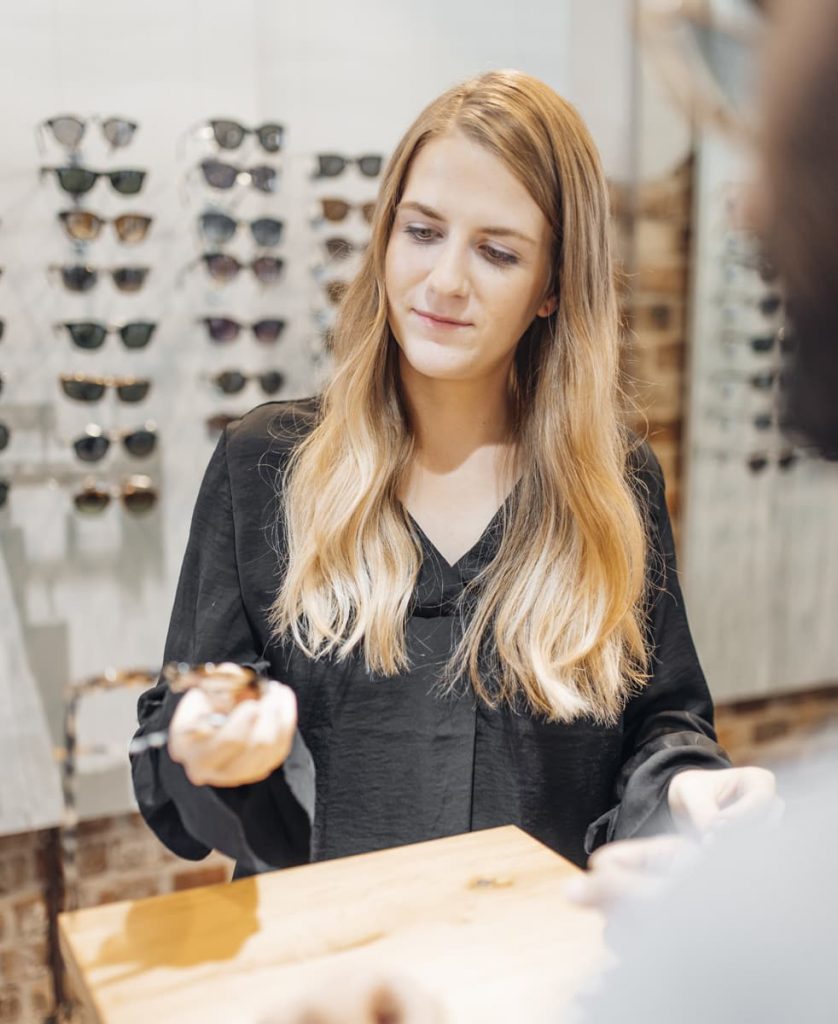 Frau hält eine neue Brille in der Hand