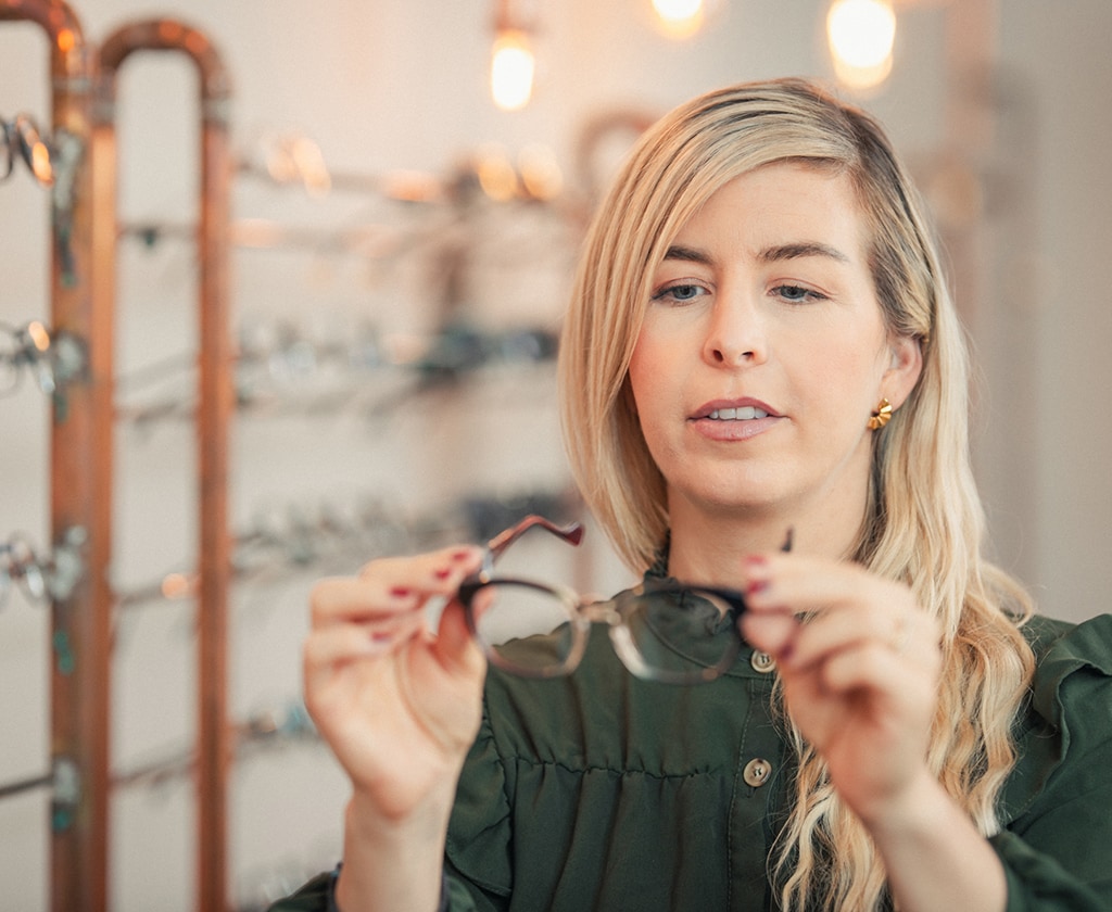 Kundin betrachtet eine Lesebrille im Fachgeschäft Top Optik Stuttgart