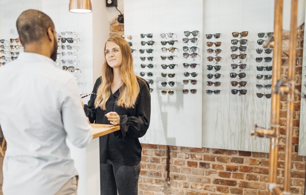 Frau kauft eine Sonnenbrille beim Optiker